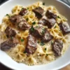 Rindfleisch-Farfalle-Alfredo Rezept Zutaten: - 250 g Farfalle - 300 g Rinderhackfleisch - 200 ml Sahne - 100 g Parmesan, gerieben - 1 Zwiebel, gewürfelt - 2 Knoblauchzehen, gehackt - 2 EL Olivenöl - Salz und Pfeffer nach Geschmack - Frische Petersilie zur Garnitur Anleitung: 1. Farfalle nach Packungsanweisung kochen, abtropfen lassen. 2. In einer Pfanne Olivenöl erhitzen, Zwiebel und Knoblauch anbraten bis sie goldbraun sind. 3. Rinderhackfleisch hinzufügen, gut anbraten und mit Salz und Pfeffer würzen. 4. Sahne in die Pfanne geben und zum Kochen bringen. 5. Parmesan unterrühren und die Sauce einige Minuten köcheln lassen. 6. Gekochte Farfalle mit der Sauce vermengen. 7. Mit frischer Petersilie garnieren und servieren.