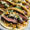 Gegrillte Elote Steak Tacos Rezept Zutaten: - 500 g Steak - 4 Tortillas - 2 Tassen Mais - 1 Tasse Feta-Käse - 1/2 Tasse Koriander - 2 Limetten - 1 TL Paprika - Salz nach Geschmack - Pfeffer nach Geschmack Anleitung: 1. Steak würzen mit Salz, Pfeffer und Paprika. 2. Grill vorheizen und Steak von jeder Seite 6-8 Minuten grillen. 3. Mais in einer Pfanne anbraten bis goldbraun. 4. Tortillas in einer anderen Pfanne erhitzen. 5. Steak in Streifen schneiden und auf Tortillas verteilen. 6. Gegrillten Mais, Feta und Koriander hinzufügen. 7. Mit Limettensaft beträufeln und servieren.